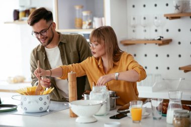 Karı koca mutfakta. Genç çift evde lezzetli yemekler hazırlıyor..