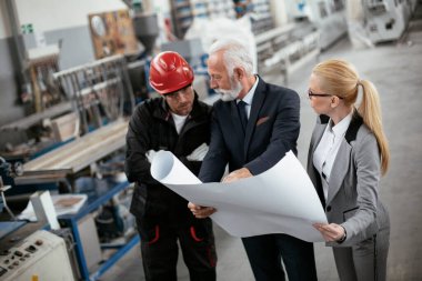 Mimarlar ve işçiler yeni projeyi planlarıyla tartışıyorlar. Fabrikada çalışan meslektaşlar..
