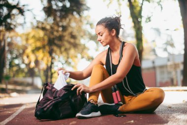 Genç bir kadın dışarıda egzersiz yapıyor.  
