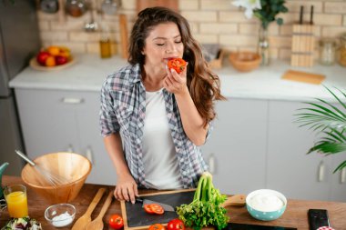 Mutfakta yemek yapan güzel genç bir kadının portresi. Genç Kadın Aşçılık. Sağlıklı Yemek - Sebze Salatası.