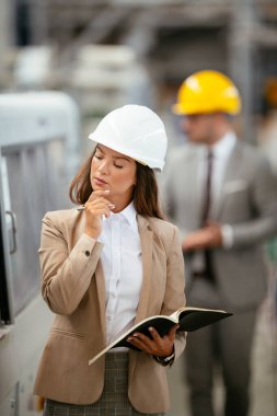 Erkek ve kadın iş tartışıyorlar. Fabrikada çalışan meslektaşlar.