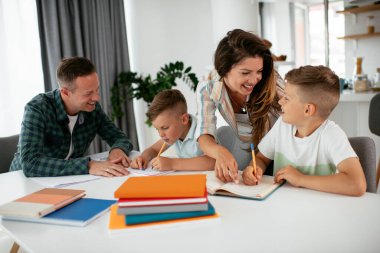 Ebeveynler çocuklara ev ödevlerinde yardım ediyorlar. Küçük çocuklar evde öğreniyor..