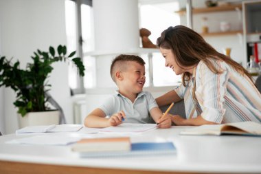 Anne oğluyla ödev yapıyor.