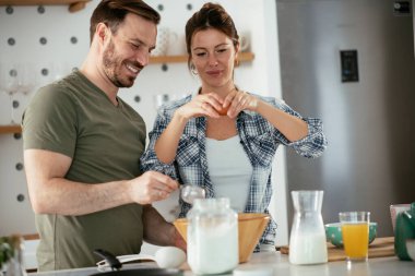 Karı koca mutfakta. Genç çift evde lezzetli yemekler hazırlıyor..