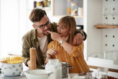 Karı koca mutfakta. Genç çift evde lezzetli yemekler hazırlıyor..