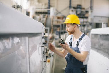 Fabrikadaki işçinin portresi. Fabrikada çalışan genç yakışıklı adam..