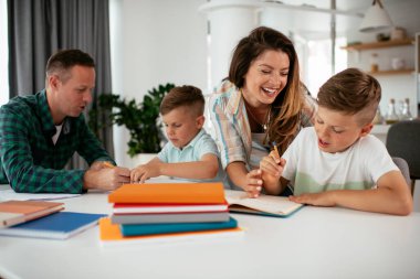 Ebeveynler çocuklara ev ödevlerinde yardım ediyorlar. Küçük çocuklar evde öğreniyor..