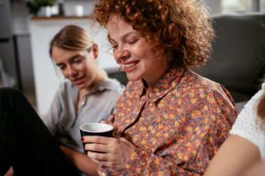 Ofiste konuşan ve gülen kızlar. Ofiste kahve içen güzel kadınlar
