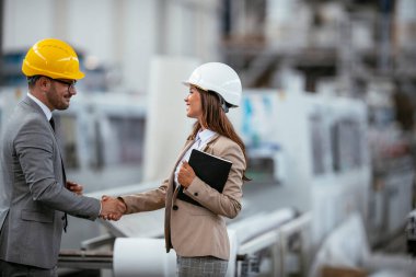 Erkek ve kadın iş tartışıyorlar. Fabrikada çalışan meslektaşlar.