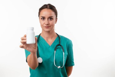 Genç kadın doktorun portresi beyaza izole edilmiş kameraya bakıyor