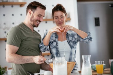 Karı koca mutfakta. Genç çift evde lezzetli yemekler hazırlıyor..