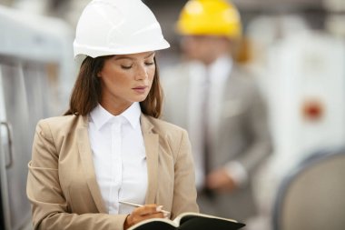 Erkek ve kadın iş tartışıyorlar. Fabrikada çalışan meslektaşlar.