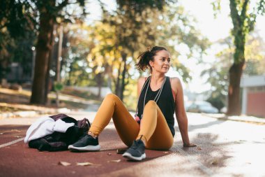 Genç bir kadın dışarıda egzersiz yapıyor.  