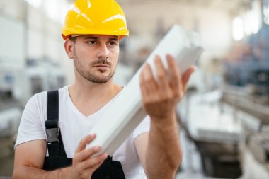 Fabrikadaki işçinin portresi. Fabrikada çalışan genç yakışıklı adam..