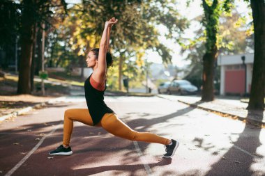 Genç bir kadın dışarıda egzersiz yapıyor. 