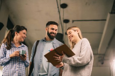 Modern açık uzay ofisinde sıradan iş adamlarından oluşan bir grup. İş kadınları ve işadamları yeni proje hakkında konuşuyor.