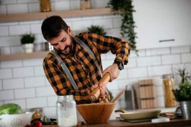 Mutfaktaki yakışıklı adamın portresi. Genç adam lezzetli yemekler hazırlıyor..