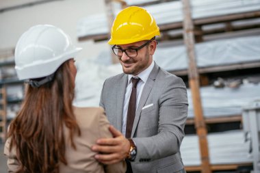 Erkek ve kadın iş tartışıyorlar. Fabrikada çalışan meslektaşlar.