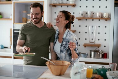 Karı koca mutfakta. Genç çift evde lezzetli yemekler hazırlıyor..