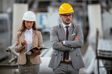 Erkek ve kadın iş tartışıyorlar. Fabrikada çalışan meslektaşlar.