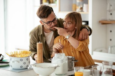 Genç çift evde kahvaltı hazırlıyor. Sevgi dolu çift mutfakta eğleniyor..