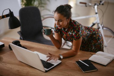 Ofiste bilgisayarla çalışan güzel genç bir iş kadını.