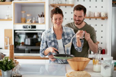 Karı koca mutfakta. Genç çift evde lezzetli yemekler hazırlıyor..