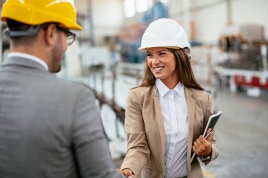 Erkek ve kadın iş tartışıyorlar. Fabrikada çalışan meslektaşlar.