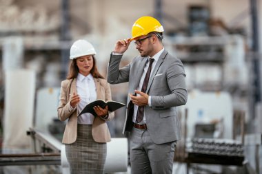 Erkek ve kadın iş tartışıyorlar. Fabrikada çalışan meslektaşlar.