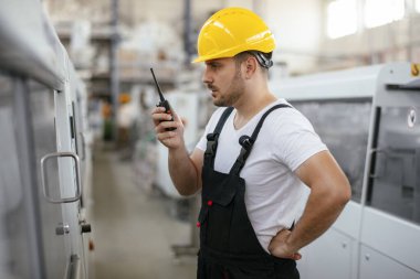 Fabrikadaki işçinin portresi. Fabrikada çalışan genç yakışıklı adam..