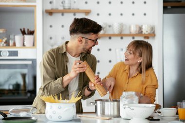 Karı koca mutfakta. Genç çift evde lezzetli yemekler hazırlıyor..