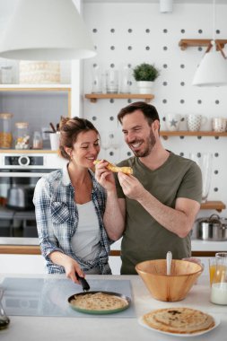 Karı koca mutfakta. Genç çift evde lezzetli yemekler hazırlıyor..