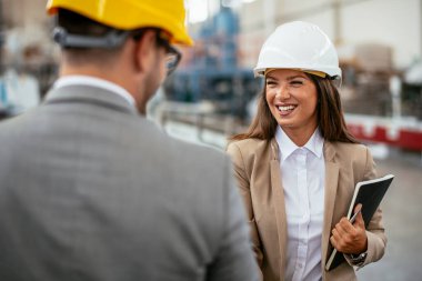 Erkek ve kadın iş tartışıyorlar. Fabrikada çalışan meslektaşlar.