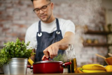 Mutfakta makarna hazırlayan yakışıklı adam. Lezzetli yemek pişiren adam..