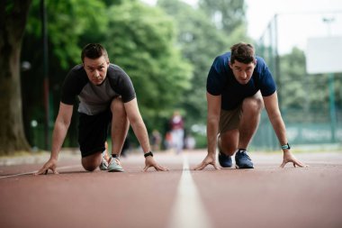 Spor giyimli sporcular koşmak için başlangıç pozisyonunda. Kapat..