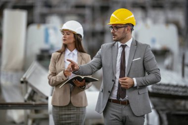 Erkek ve kadın iş tartışıyorlar. Fabrikada çalışan meslektaşlar.