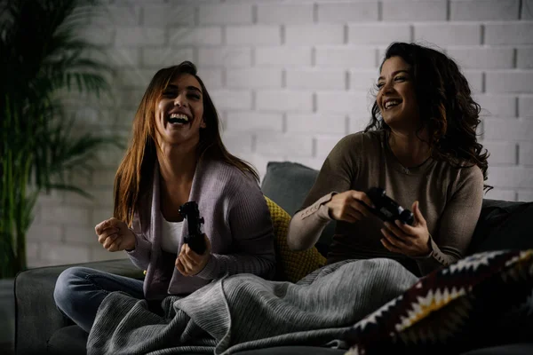 Beautiful young women playing video games at home