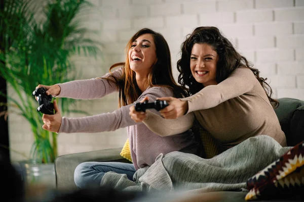 Beautiful young women playing video games at home