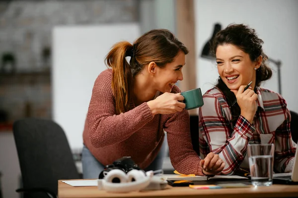 Happy businesswomen talking and laughing in open space office