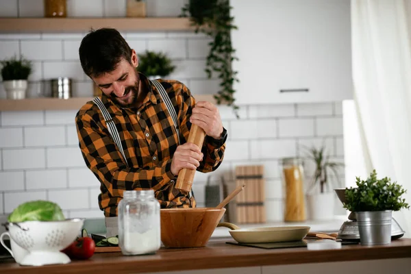 Portrait of handsome man in kitchen. Young man preparing delicious food.