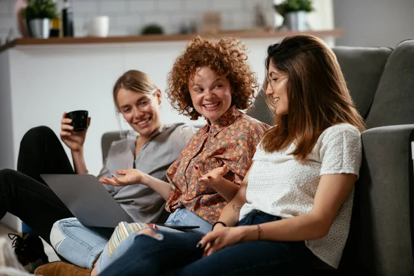 Girls talking and laughing in office. Beautiful women drinking coffee in the office