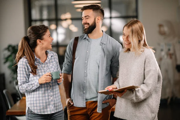 Group of casual business people talking in the modern open space office. Businesswomen and businessman talking about new project.