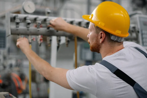 Fabrikadaki işçinin portresi. Fabrikada çalışan genç yakışıklı adam..