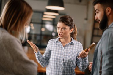 Modern açık uzay ofisinde sıradan iş adamları konuşuyor.. 