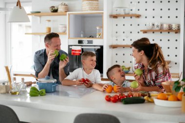Evde genç ve mutlu bir aile yemeği. Annem ve babam oğullarımla kahvaltı hazırlıyorlar..