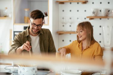 Karı koca mutfakta. Genç çift evde lezzetli yemekler hazırlıyor..