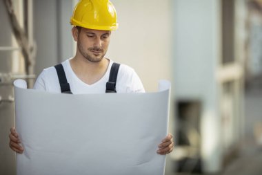 Sokakta sarı kasklı yakışıklı bir işçinin portresi.