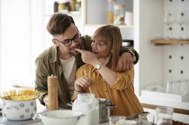 Karı koca mutfakta. Genç çift evde lezzetli yemekler hazırlıyor..