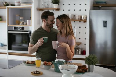 Çift evde birlikte yemek pişiriyor ve yemek hazırlıyor.