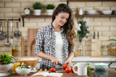 Mutfakta yemek yapan güzel genç bir kadının portresi. Genç Kadın Aşçılık. Sağlıklı Yemek - Sebze Salatası.